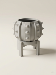 Vaso Alver a forma di cactus a barile con sottovaso e supporto a quattro gambe, stampato in 3D in PLA grigio chiaro.
