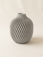 Vaso Kivan a forma di uovo con nervature sottili a spirale, stampato in 3D in PLA grigio chiaro.