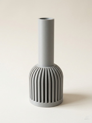 Vaso design Lira di KILAU, colore grigio chiaro, con base a lamelle verticali e collo cilindrico, ideale per decorazione d'interni.