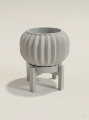 Vaso Olin a botte con sottili pieghe verticali, con sottovaso e supporto a quattro gambe, stampato in 3D in PLA grigio chiaro.