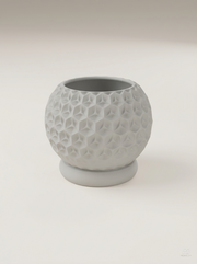Vaso Trihex grigio chiaro con stelle sfaccettate e sottovaso separato, vuoto, visto di tre quarti.